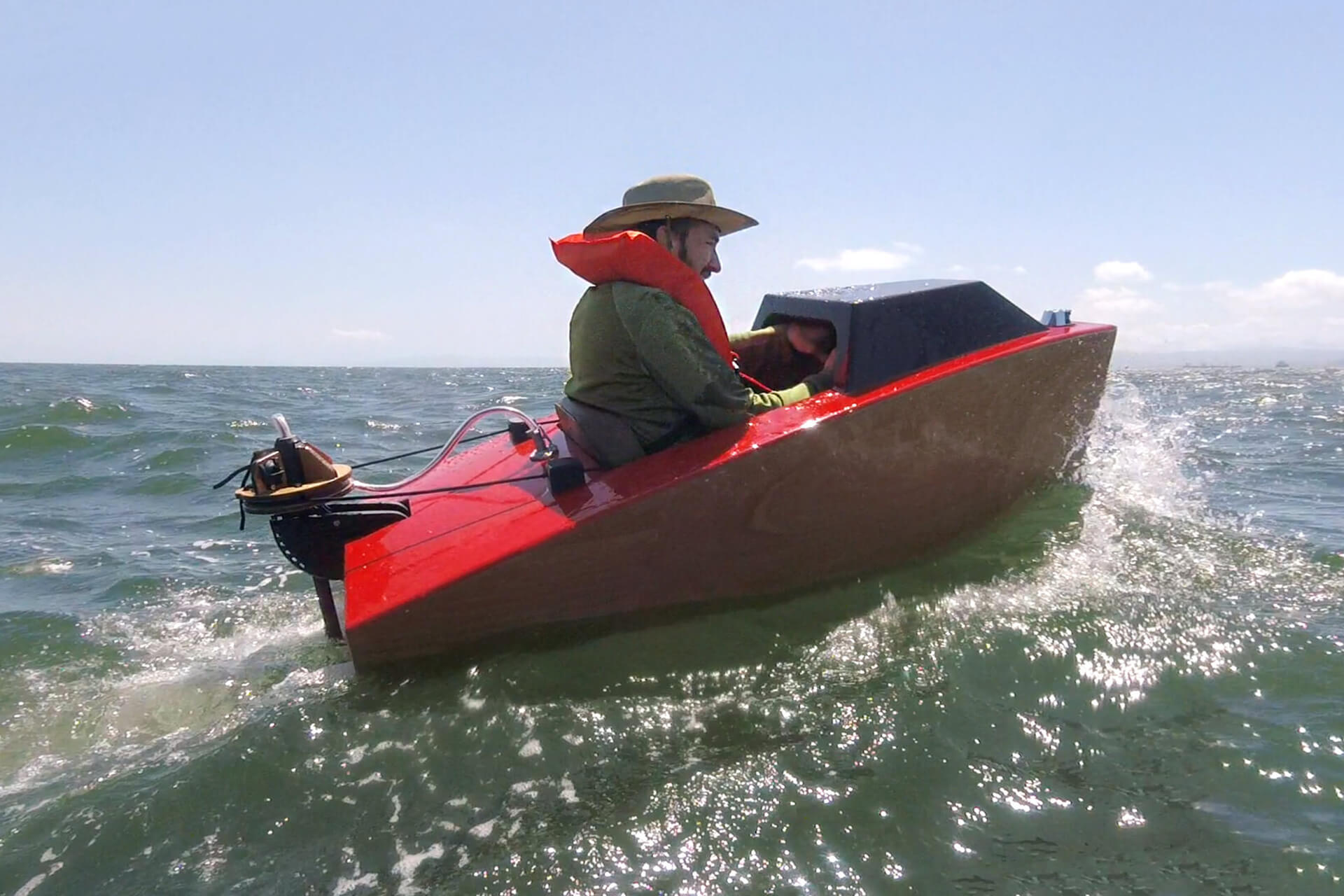 Josh riding in choppy ocean water in his mini boat.