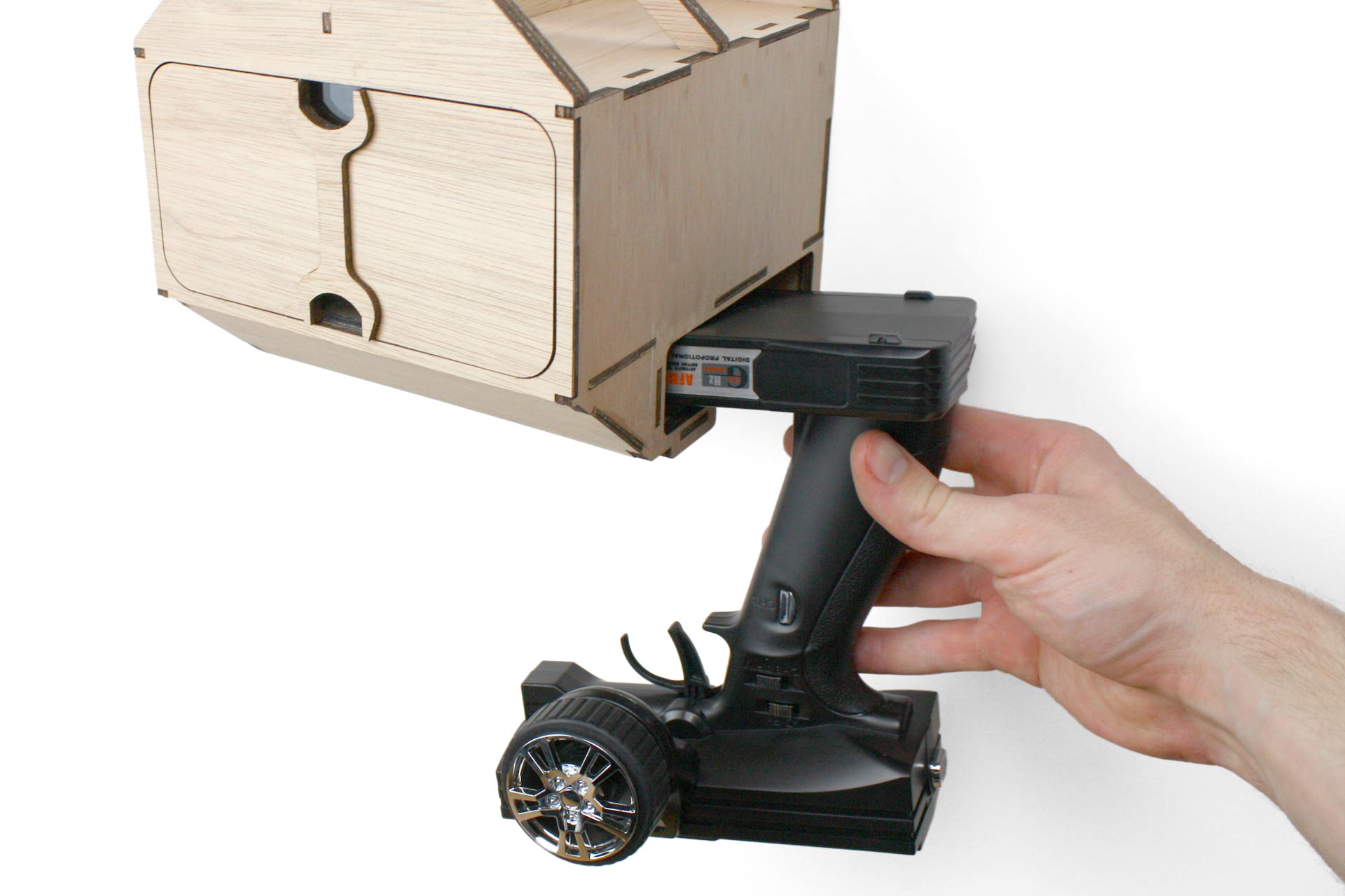 A hand removing the controller from the RC Wall Mount.